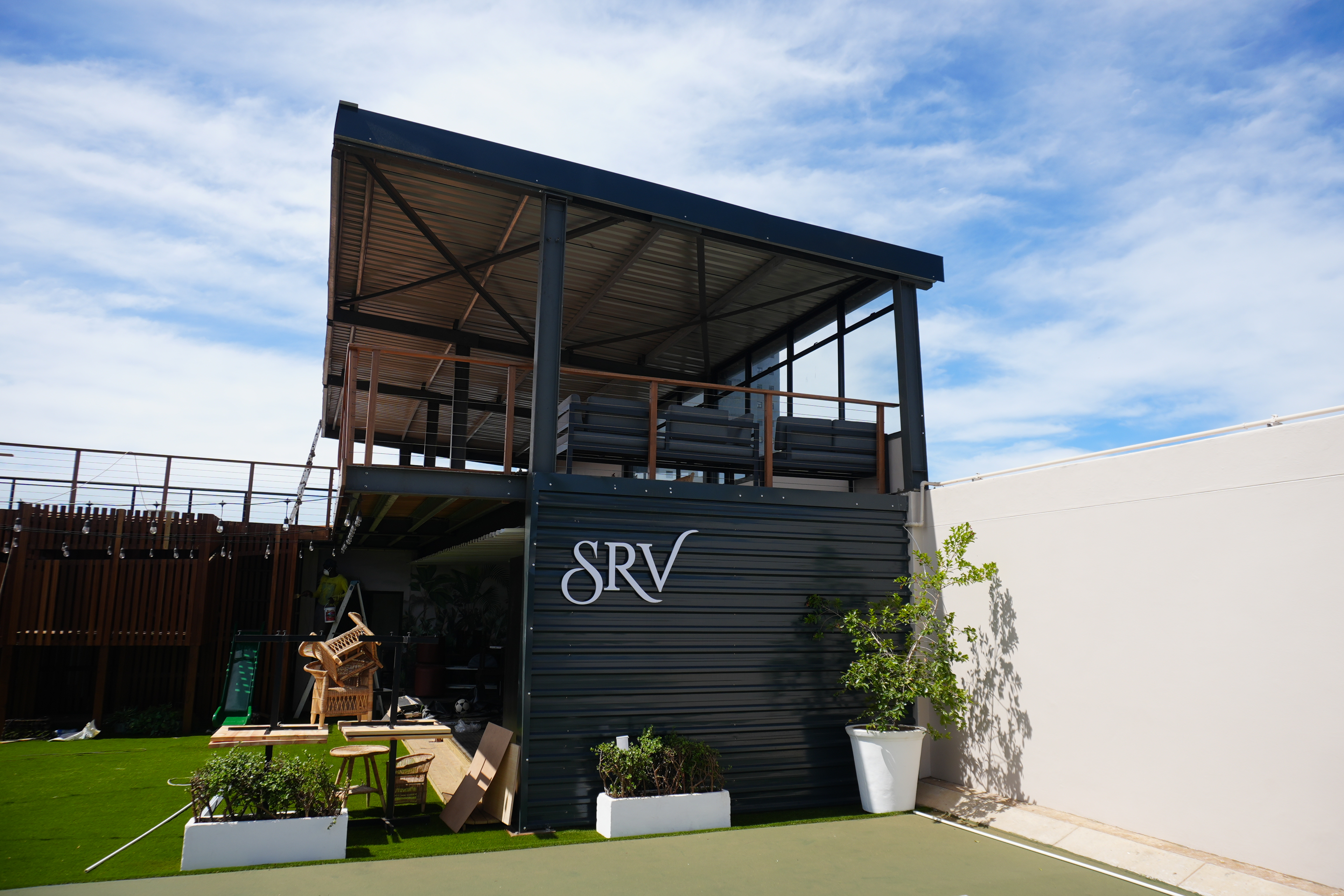 Players mid-rally on a floodlit padel court