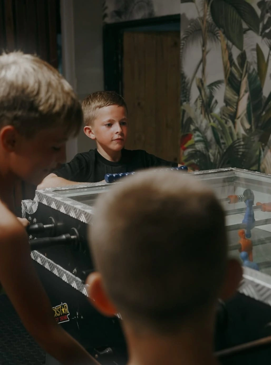 Kids playing foosball indoors at SERVE
