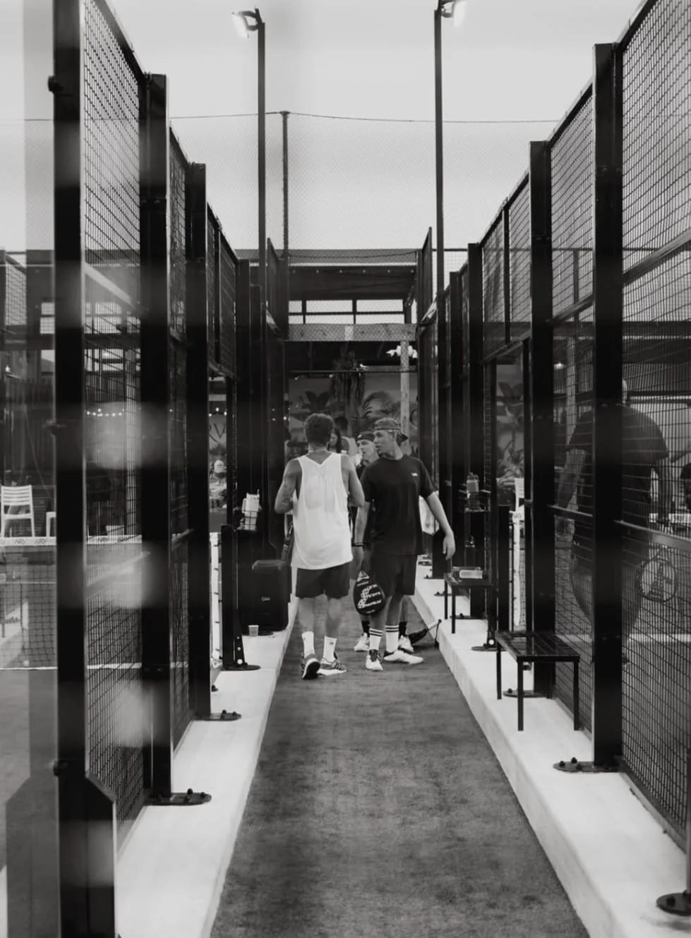 Two players walking through padel court corridors